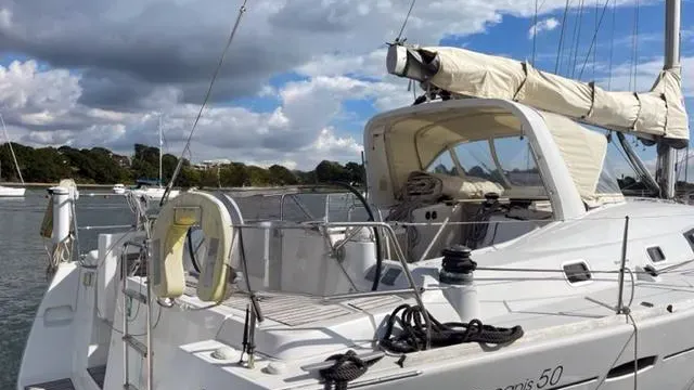 Beneteau Oceanis 50 yacht moored in a harbour with sails furled and cockpit view under a cloudy sky