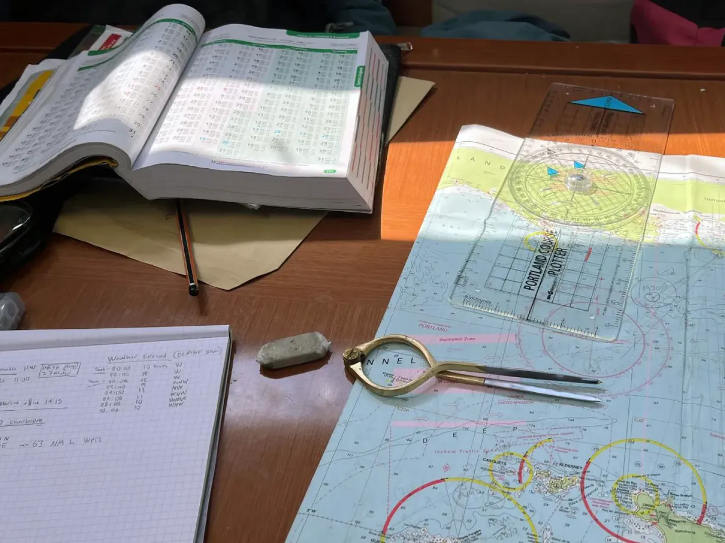 Navigation chart, tidal stream atlas and plotting tools used in sailing school training